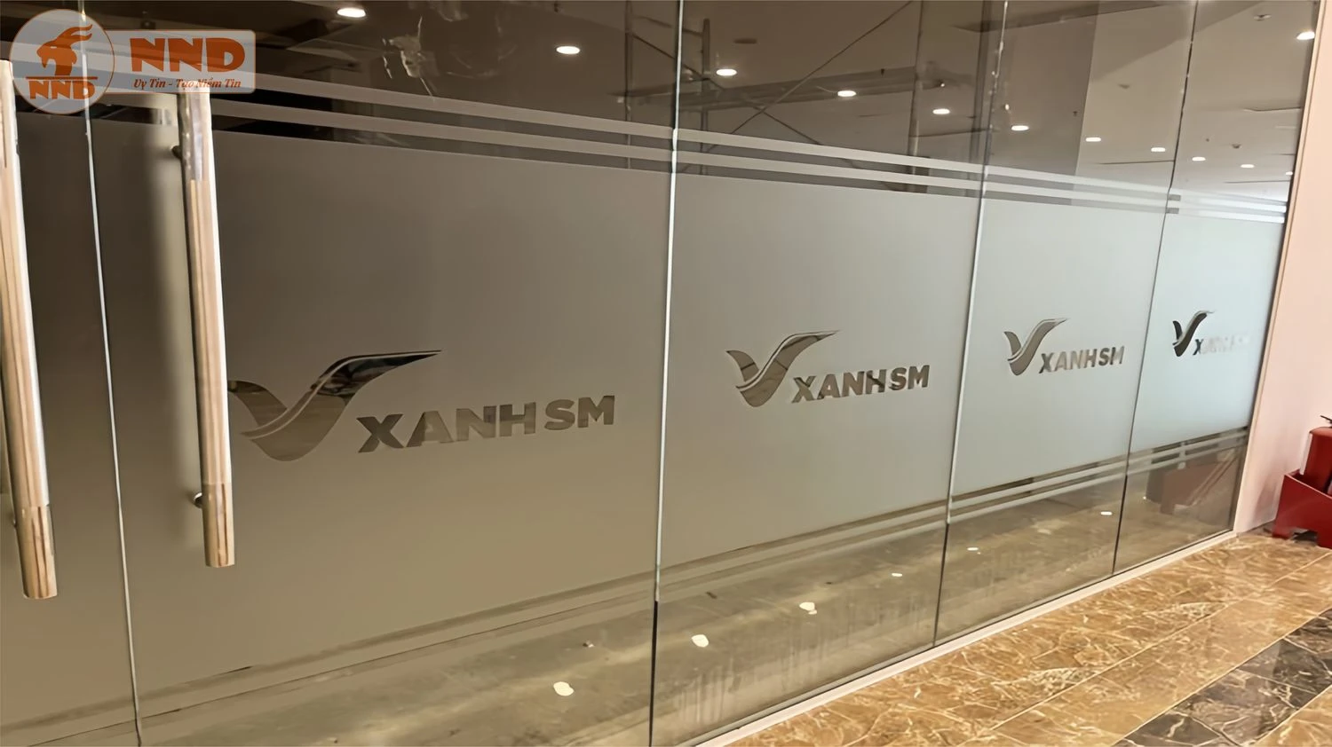 Cửa kính văn phòng thêm chuyên nghiệp với logo XanhSM cắt trên nền mờ.