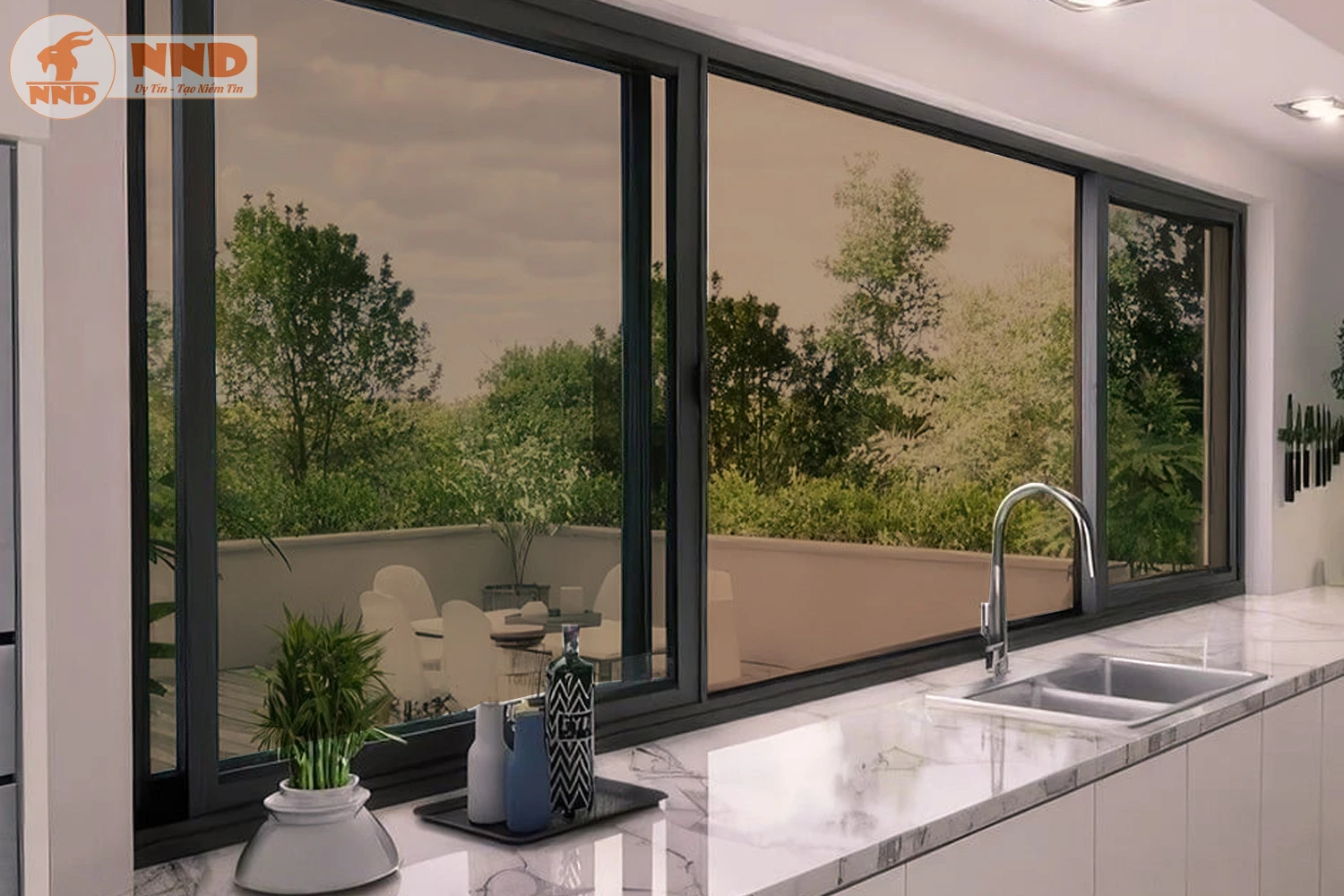 Nhà bếp với cửa sổ kính rộng nhìn ra sân thượng xanh mát