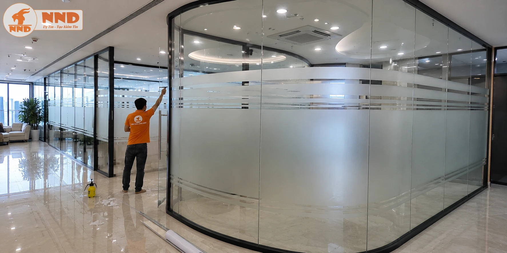 Kiểu dán decal mờ trên kính cong với khoảng mờ lớn giúp che khu vực làm việc bên trong nhưng vẫn đảm bảo ánh sáng tự nhiên xuyên qua. Hệ đường chỉ trên và dưới được bố trí đối xứng, tạo điểm nhấn nhẹ nhàng mà không làm mất đi vẻ tối giản của không gian. Mẫu này rất được ưa chuộng tại các văn phòng hiện đại.
