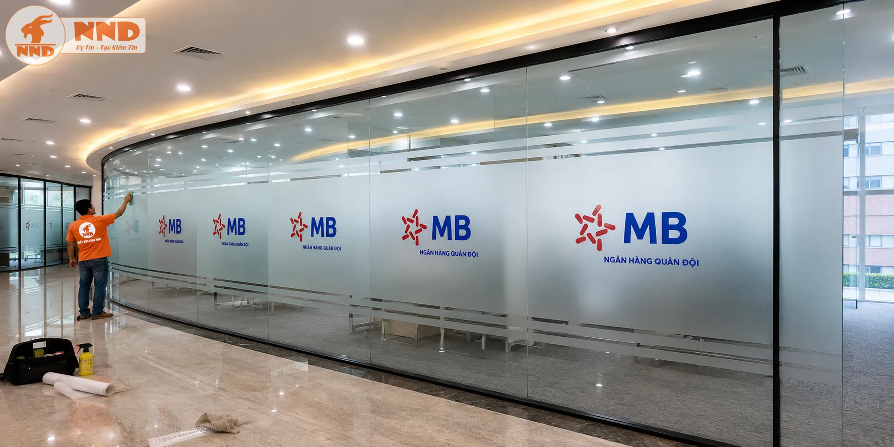 Mẫu decal mờ in logo MB Bank trên hệ vách kính văn phòng. Logo được bố trí cân đối, kết hợp đường chỉ trang trí giúp không gian hiện đại, sang trọng và dễ nhận diện thương hiệu.