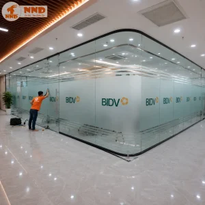 Thi công decal mờ dán kính in logo BIDV kết hợp các đường chỉ trang trí phía trên và dưới. Giải pháp vừa tạo điểm nhấn thương hiệu vừa đảm bảo ánh sáng tự nhiên và sự riêng tư cho văn phòng.