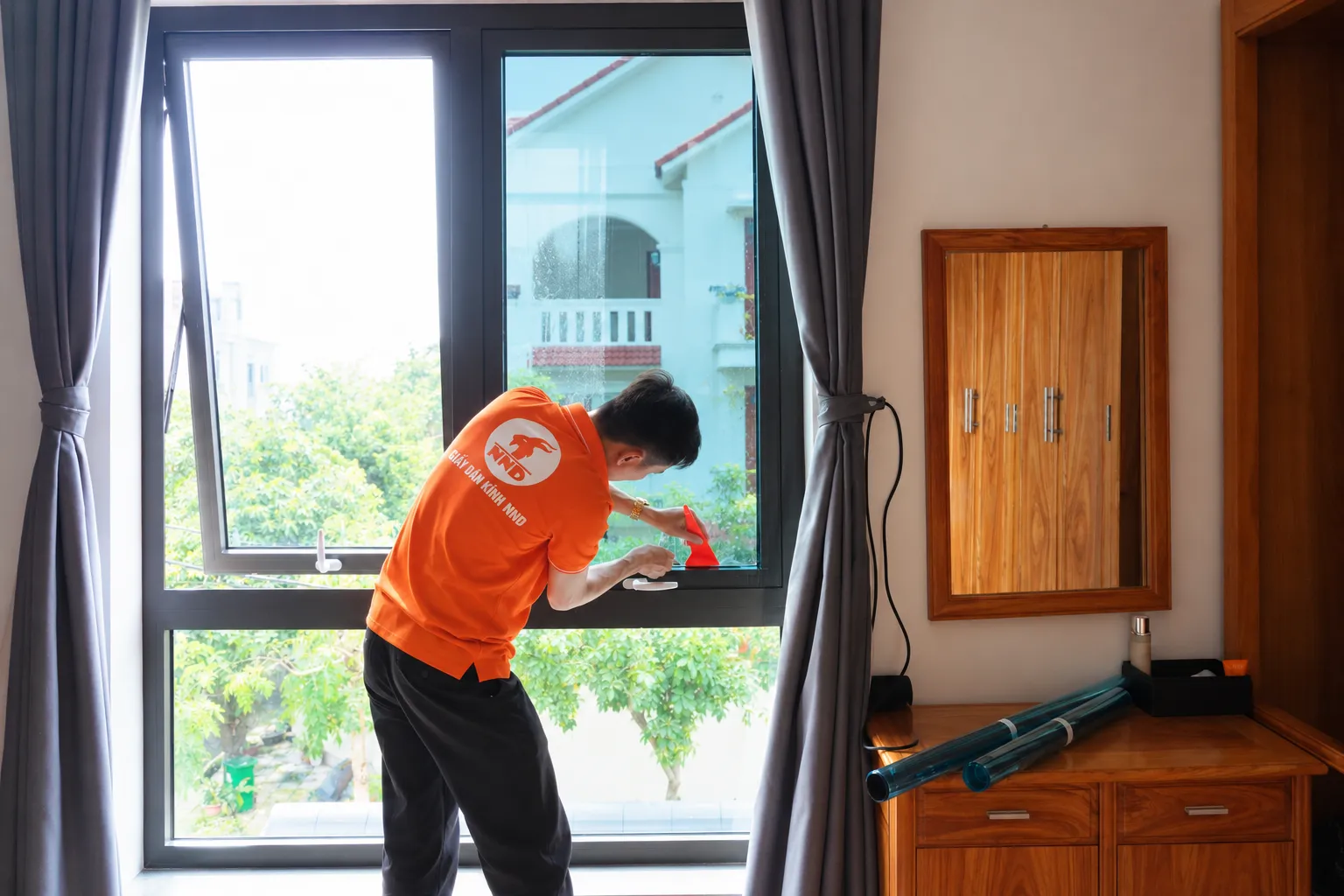 Kỹ thuật viên NND xử lý mép phim cách nhiệt AP7080 trên cửa sổ kính biệt thự Vinhomes Riverside