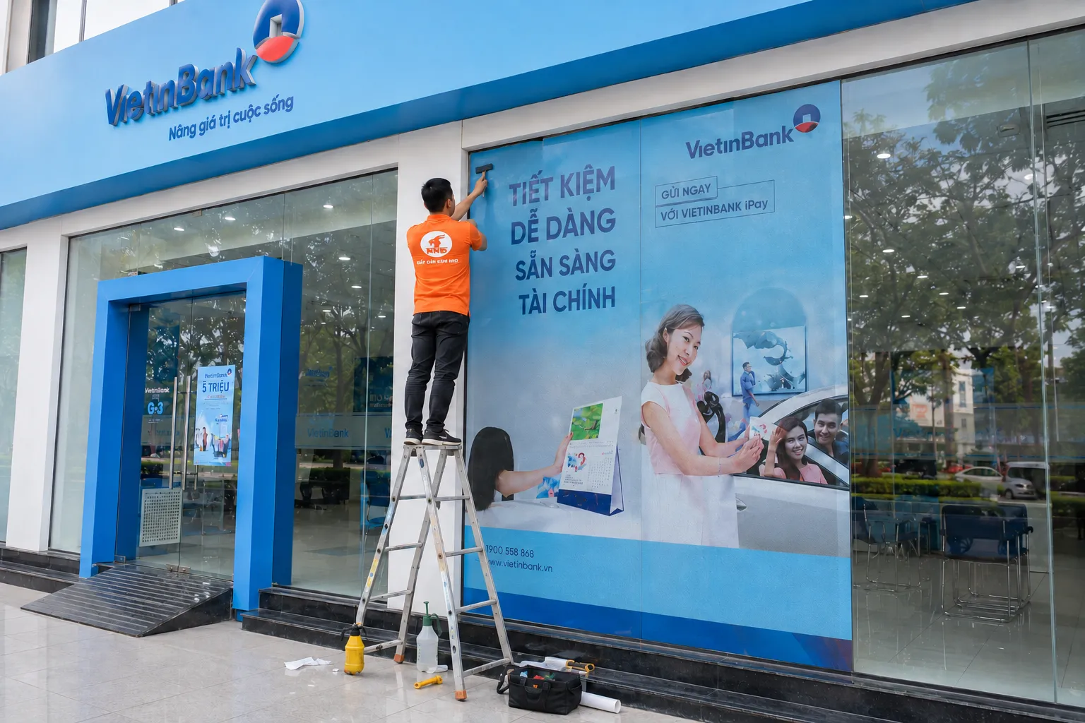 Thợ NND thi công decal lưới quảng cáo trên mặt kính VietinBank