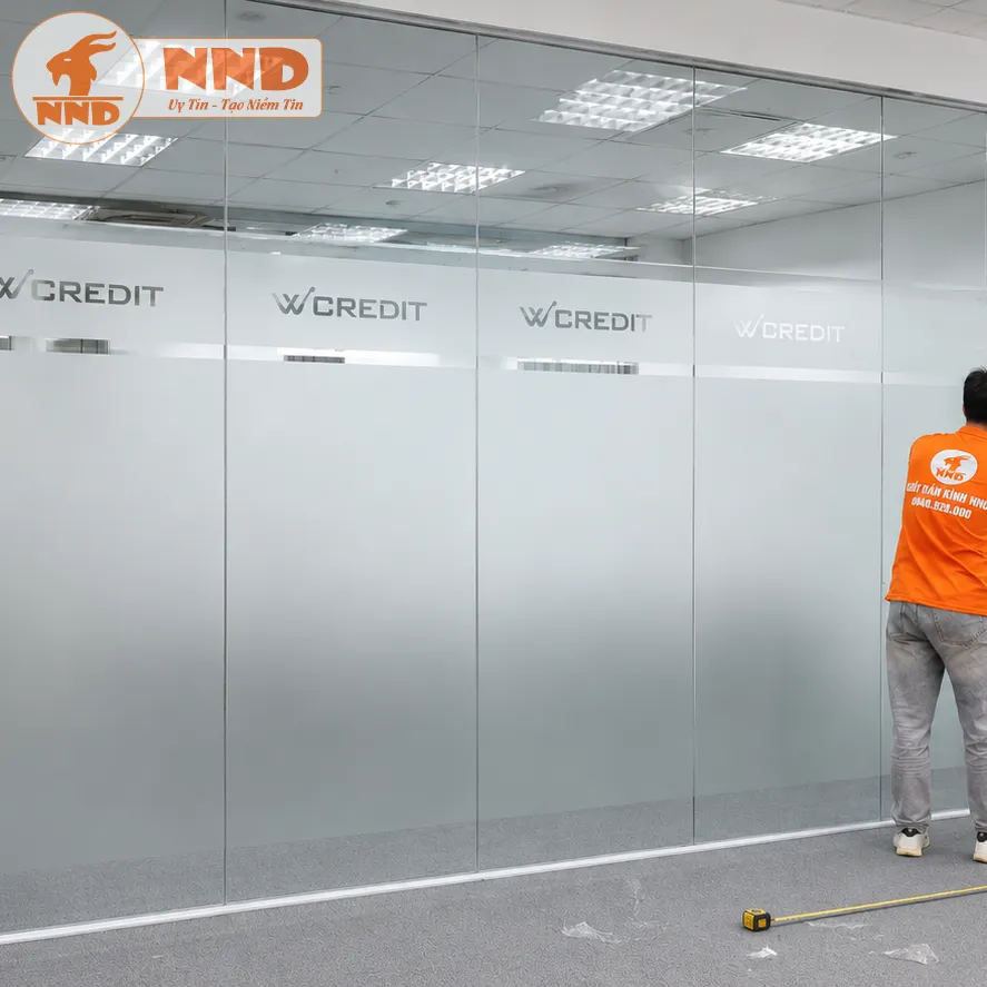 Vách kính văn phòng W Credit sử dụng decal mờ cắt logo âm bản tinh gọn ở dải trên cùng kết hợp mảng che lớn phía dưới, giúp bảo mật không gian làm việc tối ưu mà vẫn mang lại cảm giác vô cùng thoáng đãng, hiện đại.