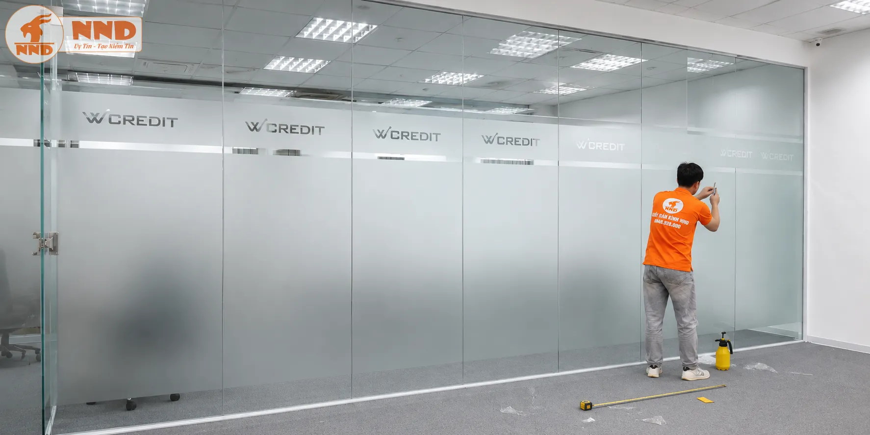 Vách kính văn phòng W Credit sử dụng decal mờ cắt logo âm bản tinh gọn ở dải trên cùng, phân chia không gian làm việc minh bạch, thoáng đãng và mang lại cảm giác cực kỳ thanh lịch, an tâm.
