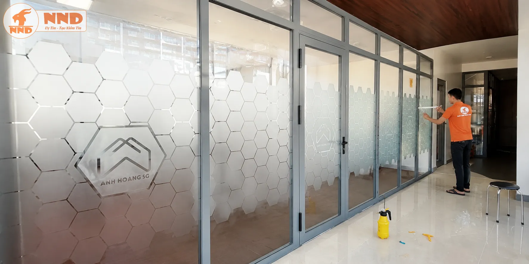 Decal mờ cắt CNC họa tiết lục giác kết hợp logo âm bản tạo không gian chuyên nghiệp và nhận diện thương hiệu tinh tế. Phù hợp cho văn phòng, showroom và khu vực tiếp khách.