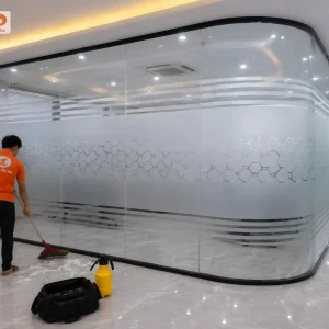 Decal mờ in họa tiết tổ ong kết hợp đường kẻ ngang tạo hiệu ứng hiện đại trên hệ vách kính cong. Thiết kế giúp không gian đồng bộ và chuyên nghiệp hơn.