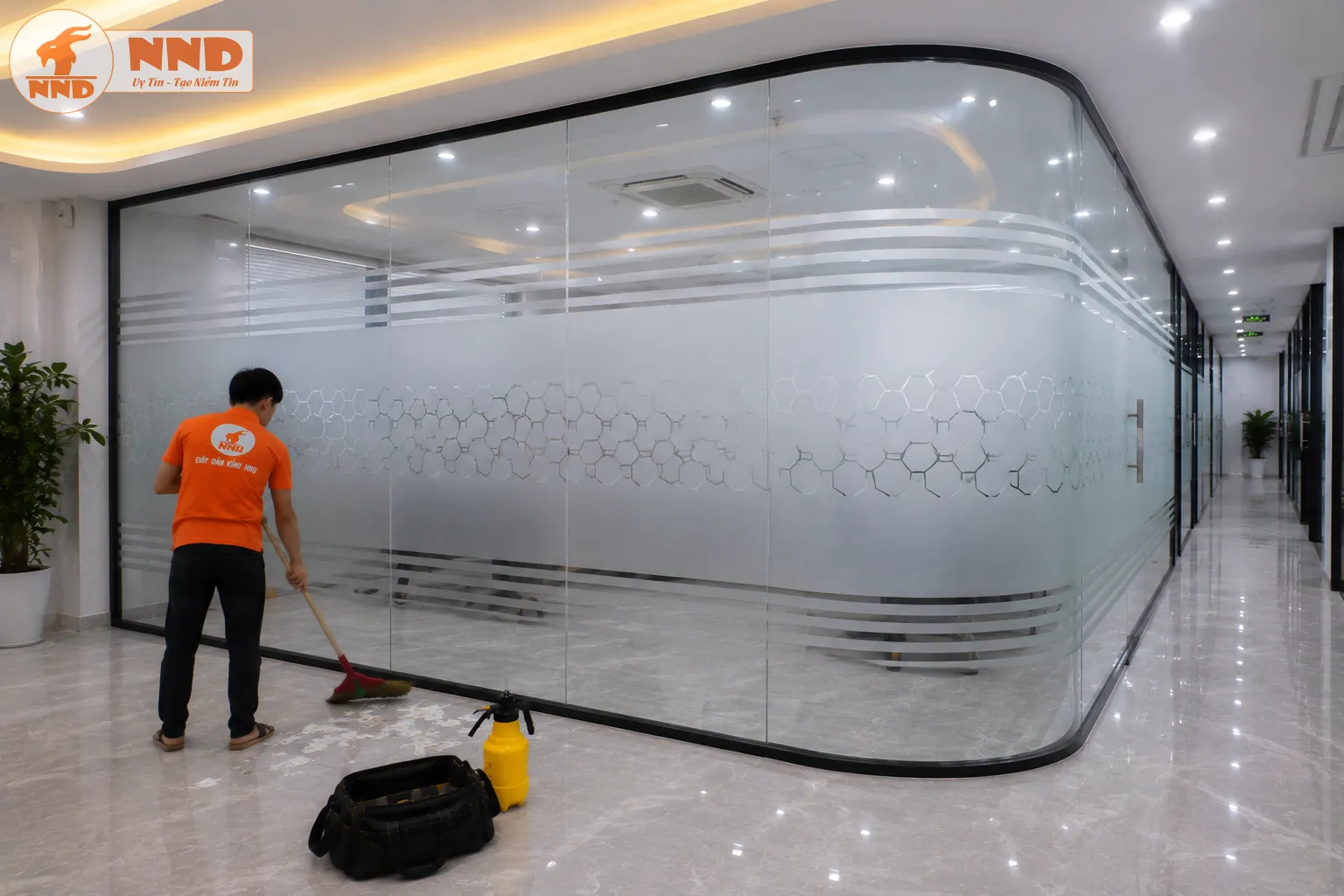 Decal mờ in họa tiết tổ ong kết hợp đường kẻ ngang tạo hiệu ứng hiện đại trên hệ vách kính cong. Thiết kế giúp không gian đồng bộ và chuyên nghiệp hơn.