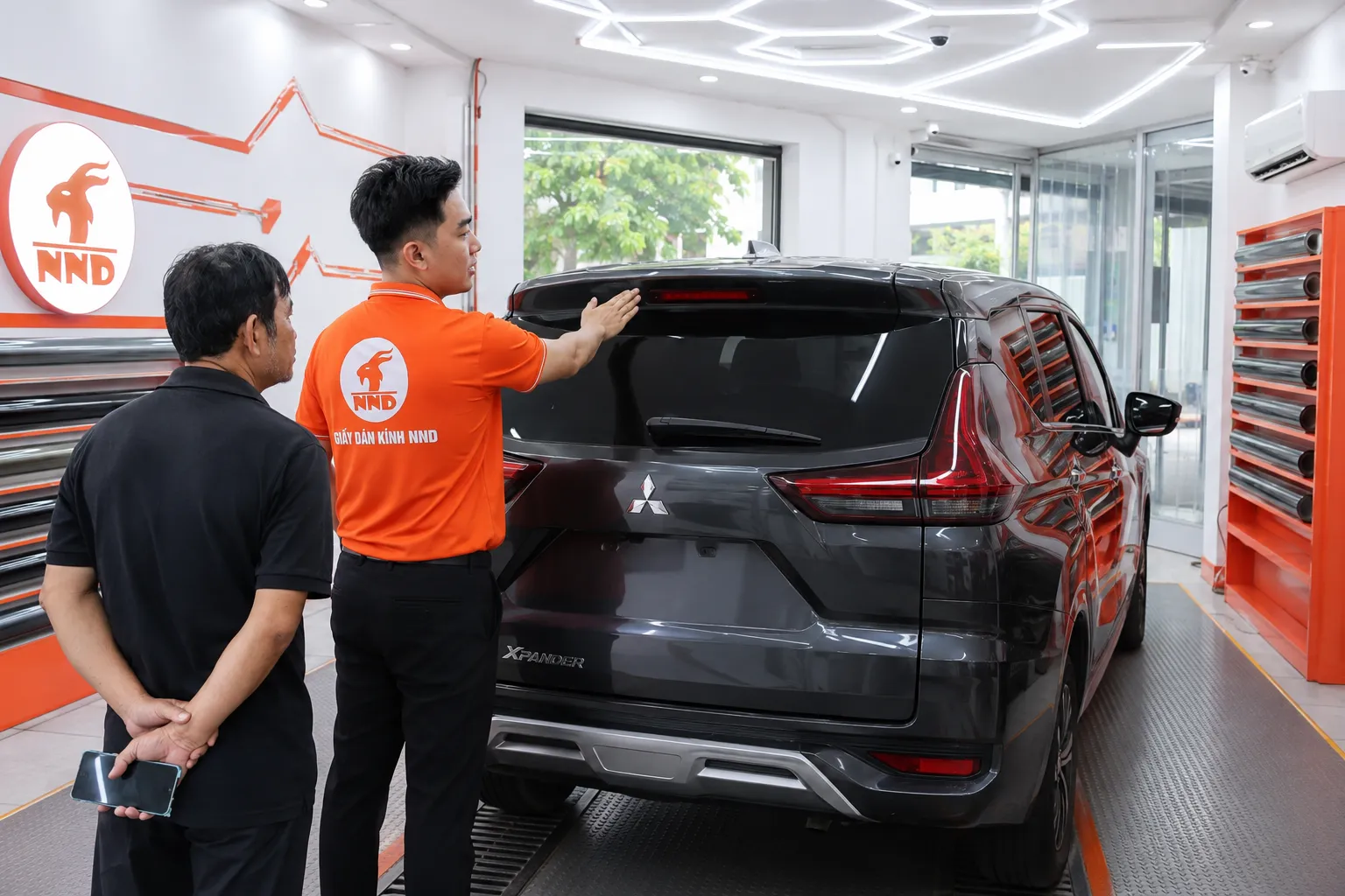 Kỹ thuật viên NND dùng súng nhiệt để định hình phim trên kính lái ô tô.