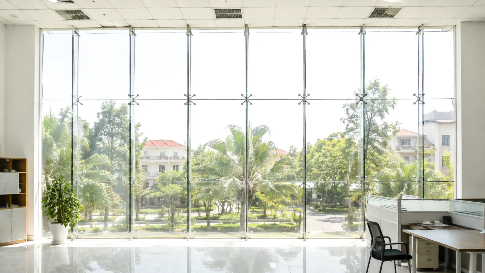 Không gian văn phòng có hệ kính lớn trước khi dán phim cách nhiệt, ánh nắng chiếu mạnh vào bên trong.