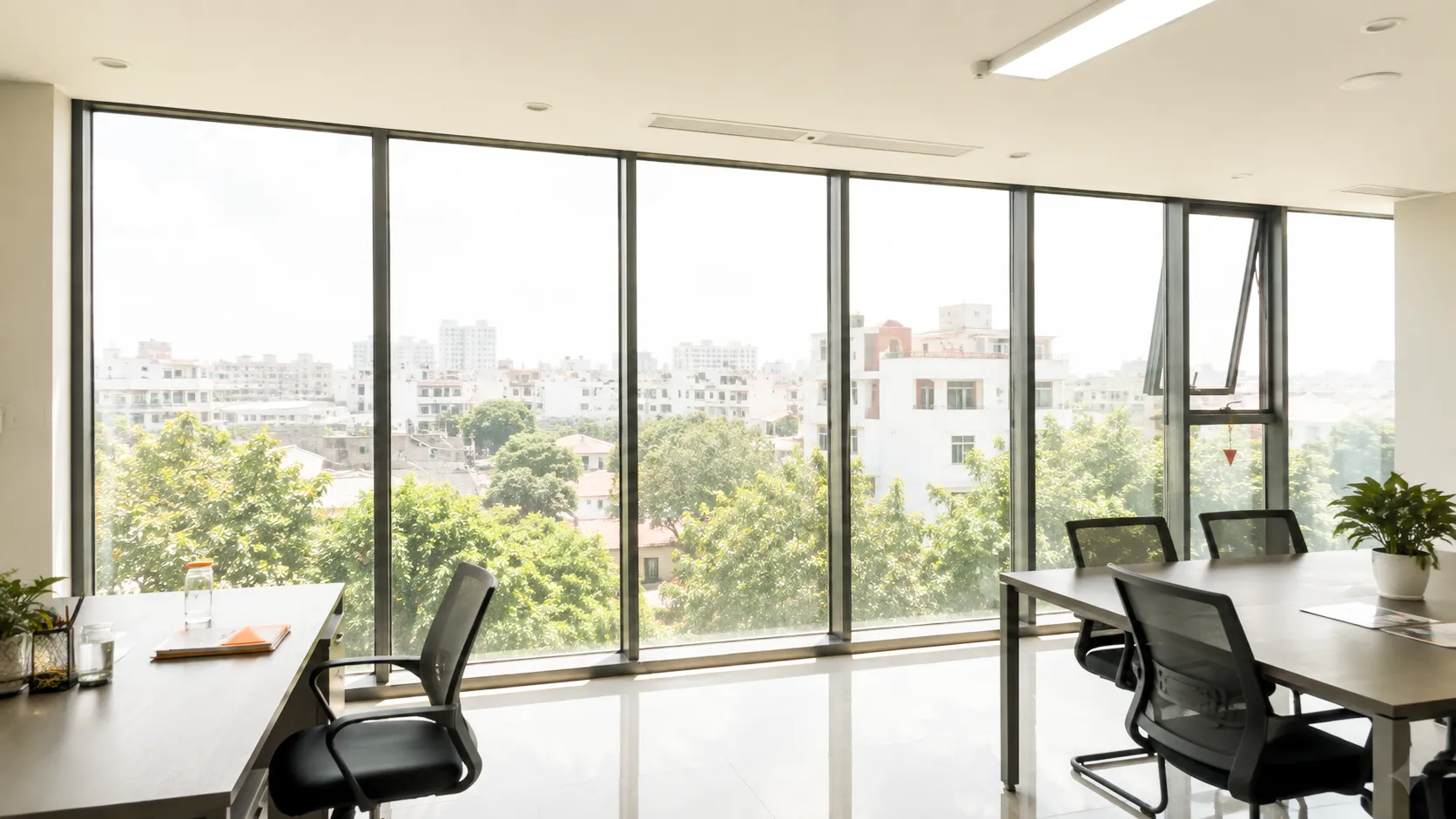 Văn phòng có hệ kính lớn trước khi dán phim cách nhiệt, ánh sáng tự nhiên chiếu trực tiếp vào khu vực làm việc.