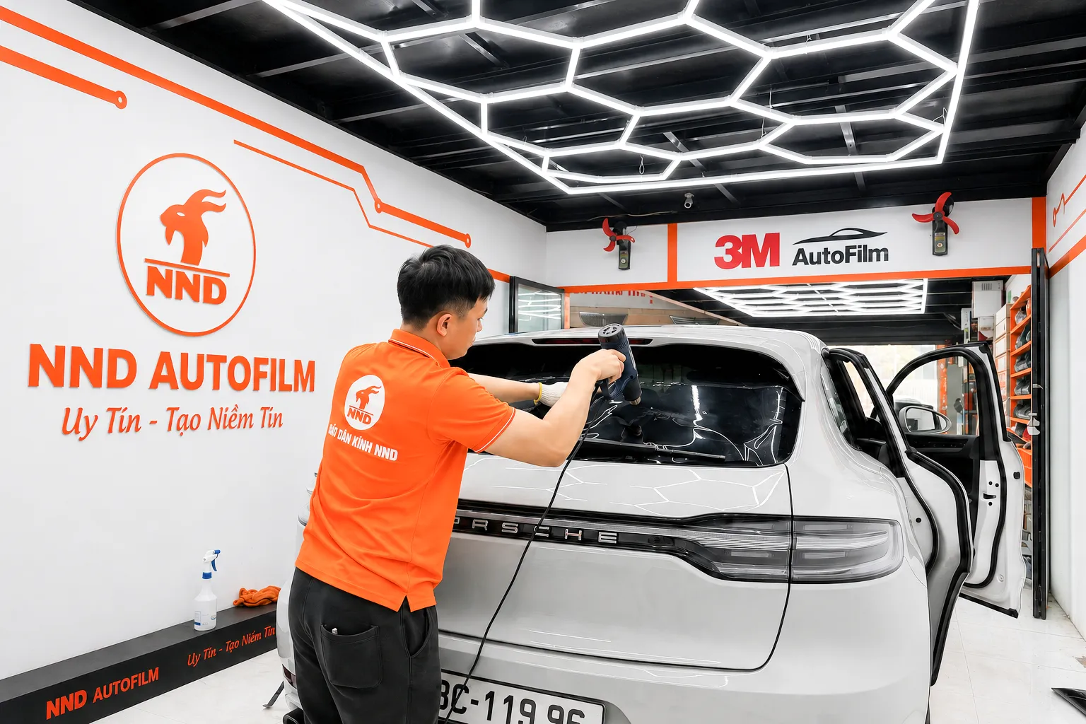 Kỹ thuật viên NND hoàn thiện phim cách nhiệt 3M cho kính hậu xe Porsche tại trung tâm NND AutoFilm
