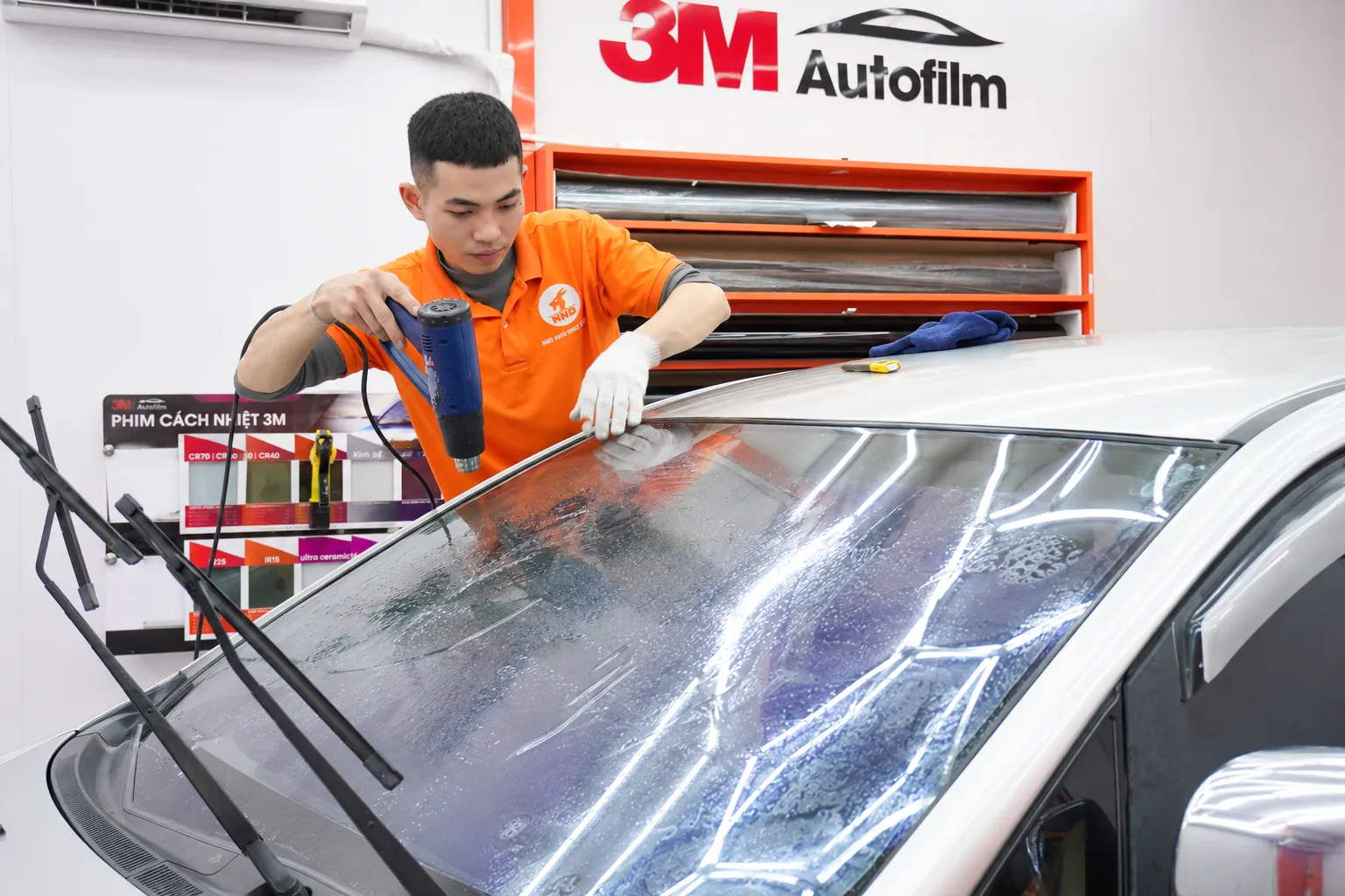 Kỹ thuật viên NND thi công phim cách nhiệt trên kính lái Toyota Innova