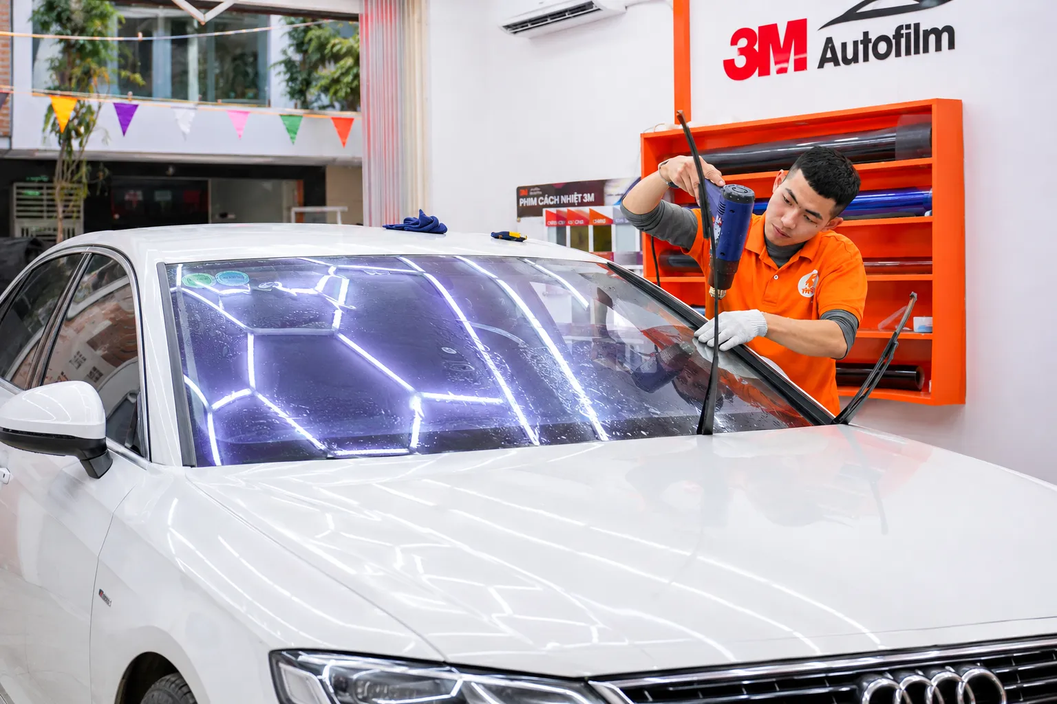 Kỹ thuật viên NND thi công phim cách nhiệt trên kính lái Audi A7 của anh Tiến
