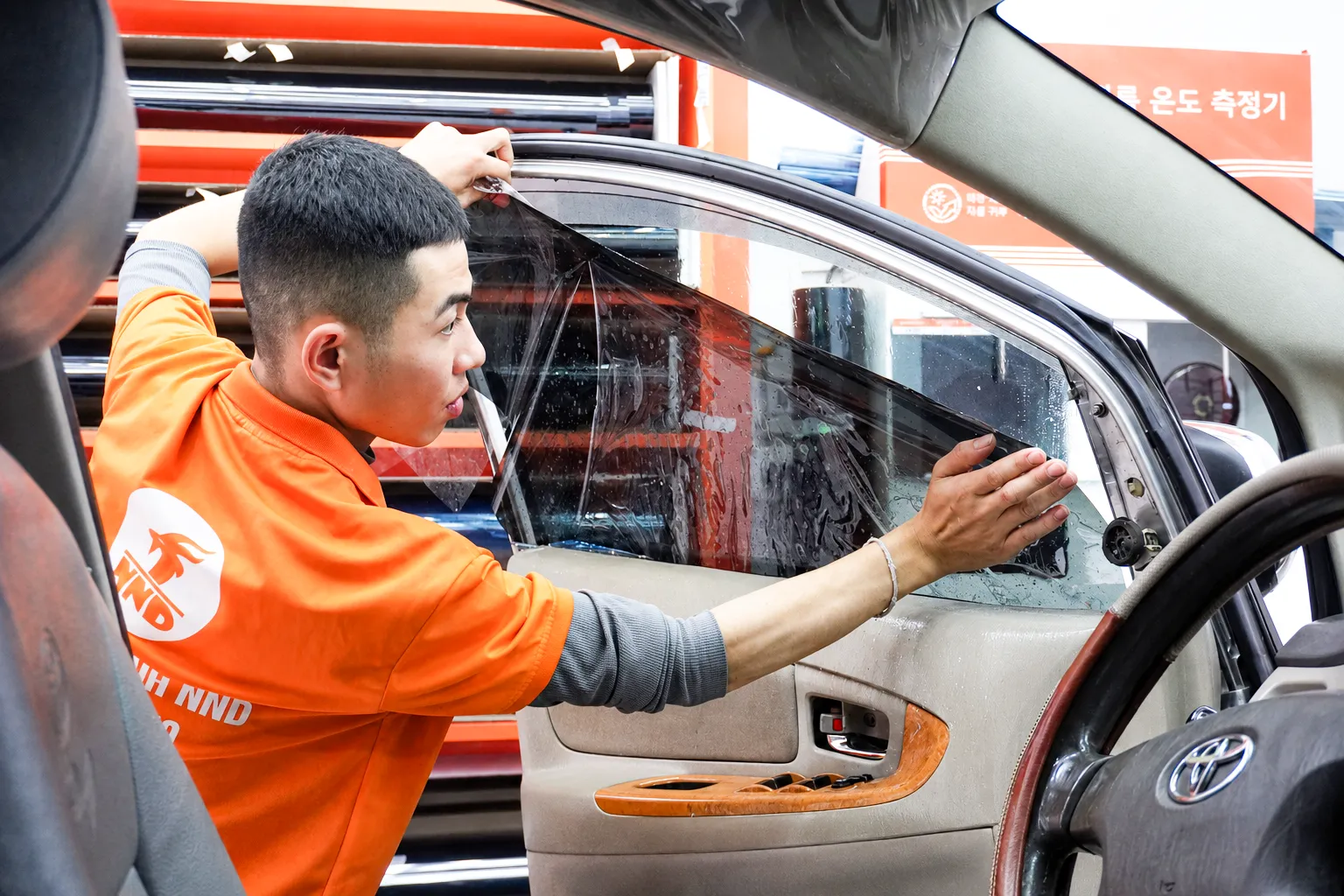 Kỹ thuật viên NND căn chỉnh phim cách nhiệt trên kính cửa Toyota Innova