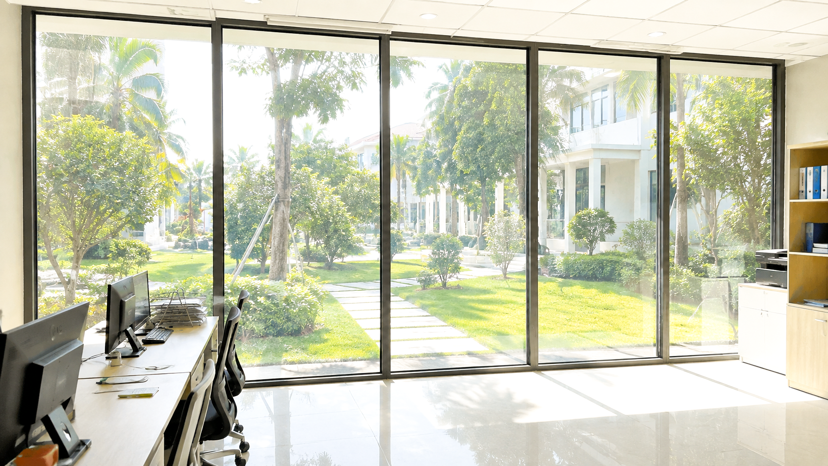 Văn phòng có hệ cửa kính lớn trước khi dán phim cách nhiệt, ánh nắng chiếu trực tiếp vào khu vực làm việc.