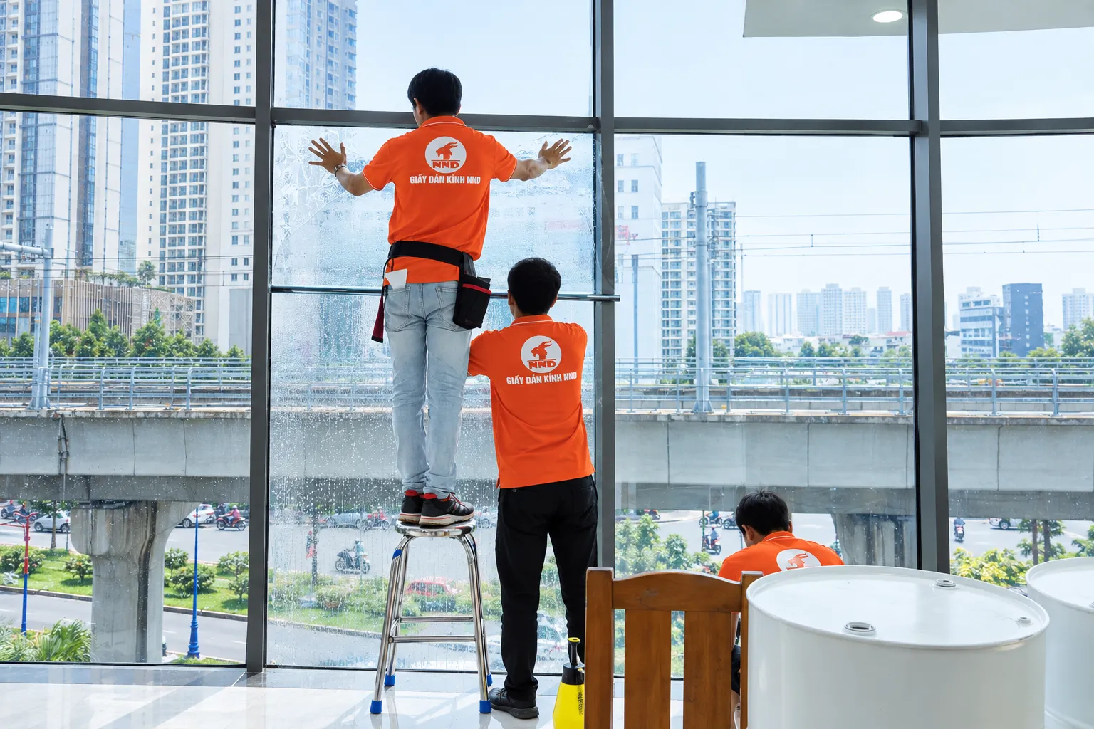 Đội kỹ thuật NND căn chỉnh phim cách nhiệt trên mảng kính lớn tại tòa nhà Sun Square