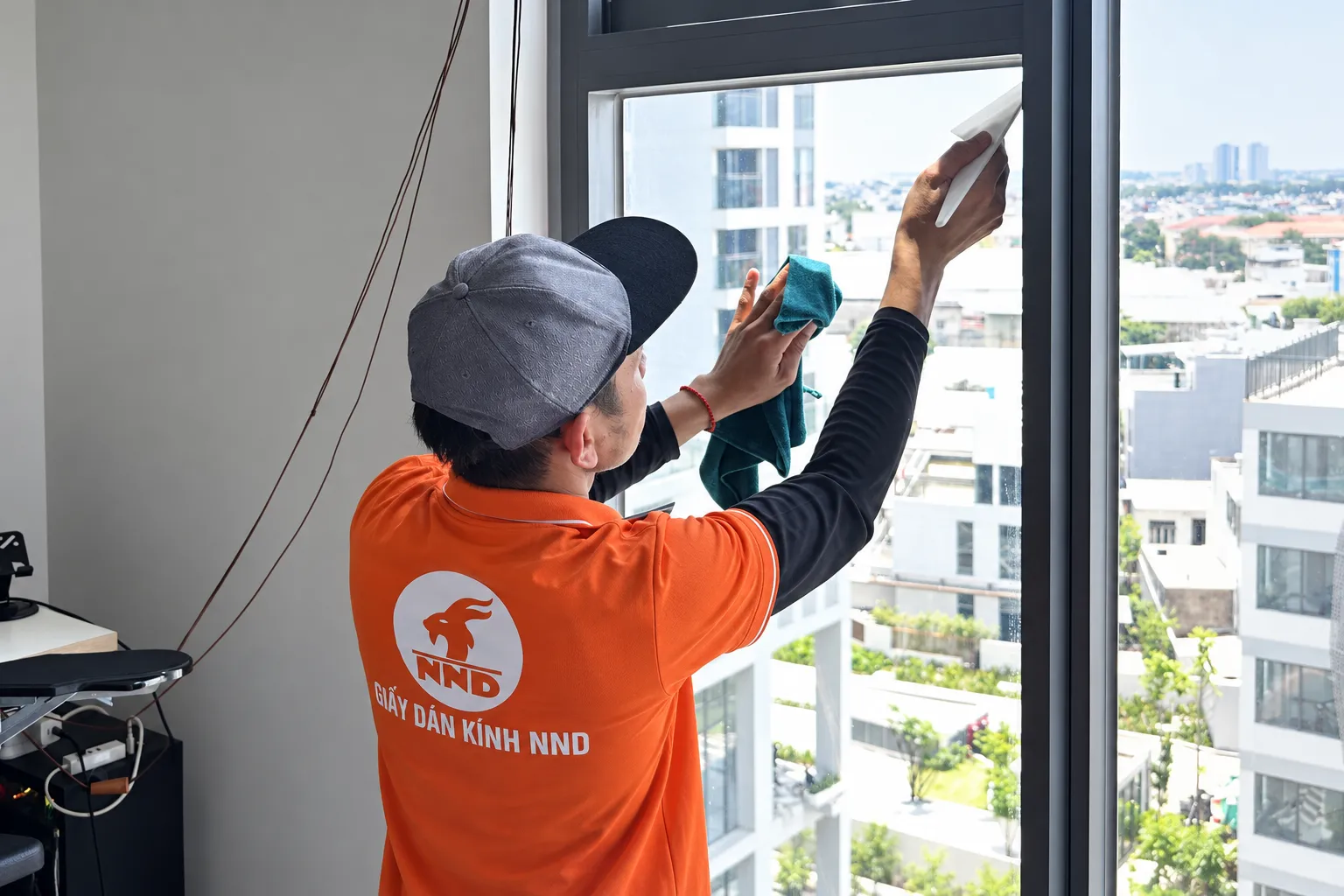 Kỹ thuật viên NND vệ sinh bề mặt kính tại căn hộ Masteri West Heights trước khi dán phim
