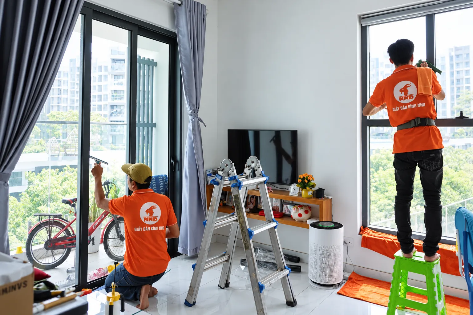 Kỹ thuật viên NND vệ sinh và chuẩn bị các ô kính trước khi dán phim tại Vinhomes Grand Park