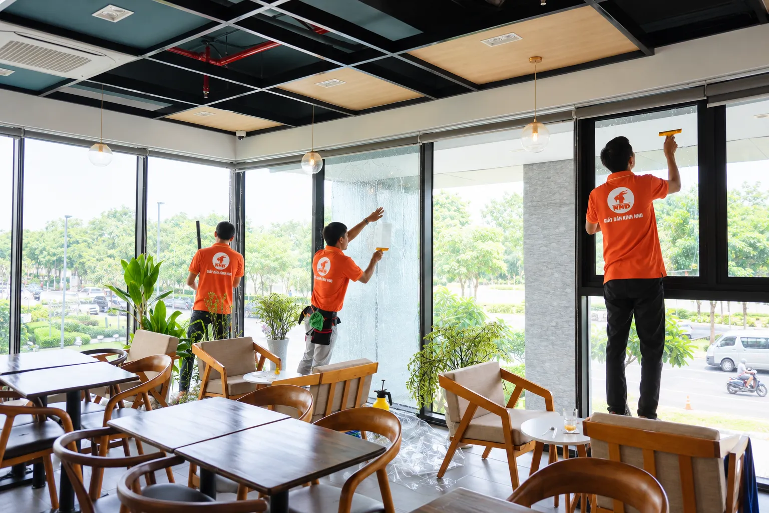 Đội kỹ thuật NND vệ sinh các mảng kính lớn tại quán cà phê Tropical Forest