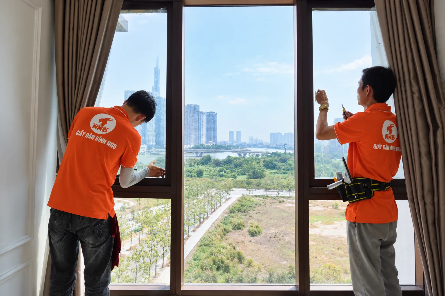 Hai kỹ thuật viên NND xử lý và căn mép phim cách nhiệt trên hệ kính biệt thự Vinhomes Ocean Park