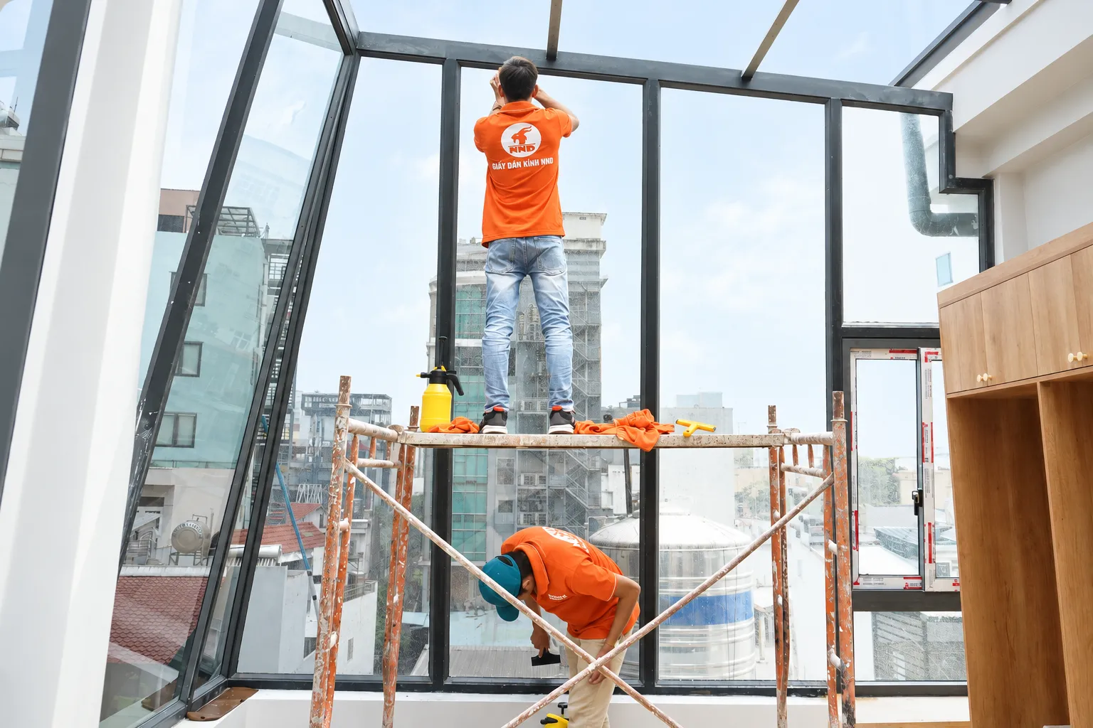 Đội NND chuẩn bị bề mặt kính trên giàn giáo tại công trình Kiến Hưng