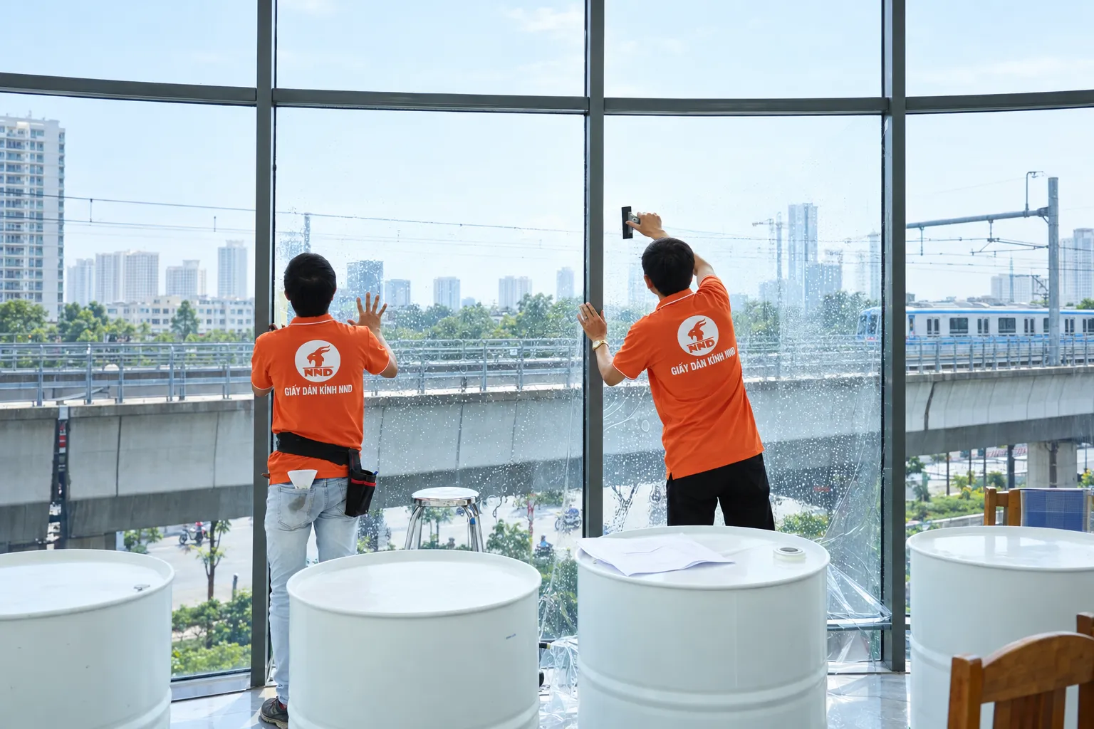 Kỹ thuật viên NND gạt dung dịch trên bề mặt phim cách nhiệt tại hệ kính Sun Square