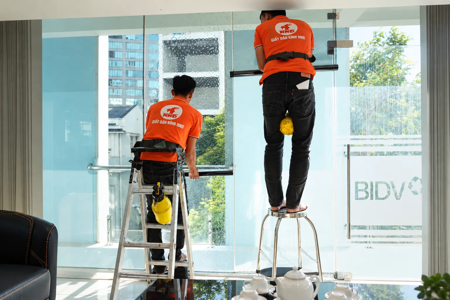 Kỹ thuật viên NND thi công phim cách nhiệt NC3599 trên kính văn phòng BIDV