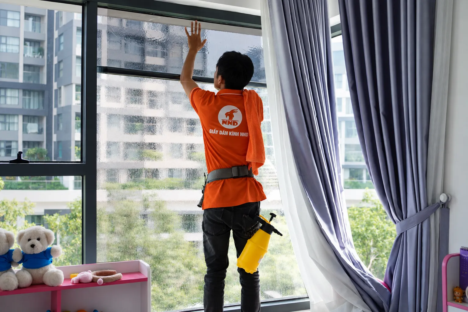Thợ NND căn chỉnh phim cách nhiệt trên cửa kính căn hộ Vinhomes Grand Park