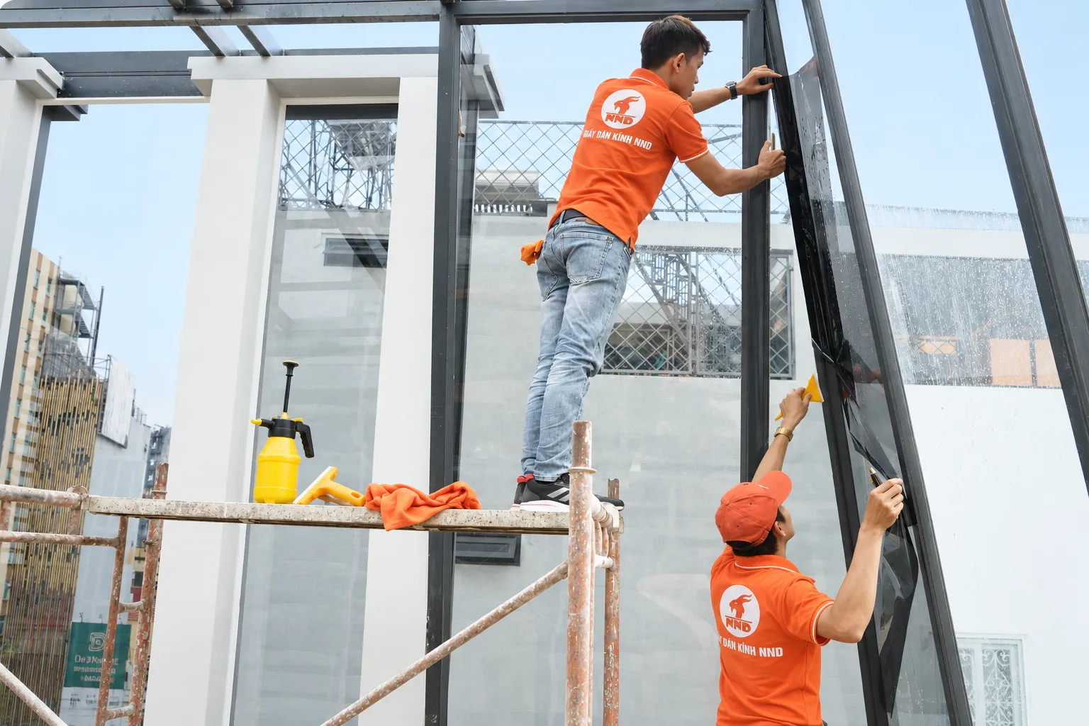 Thợ NND dán phim cách nhiệt trên vách kính nhà phố Kiến Hưng