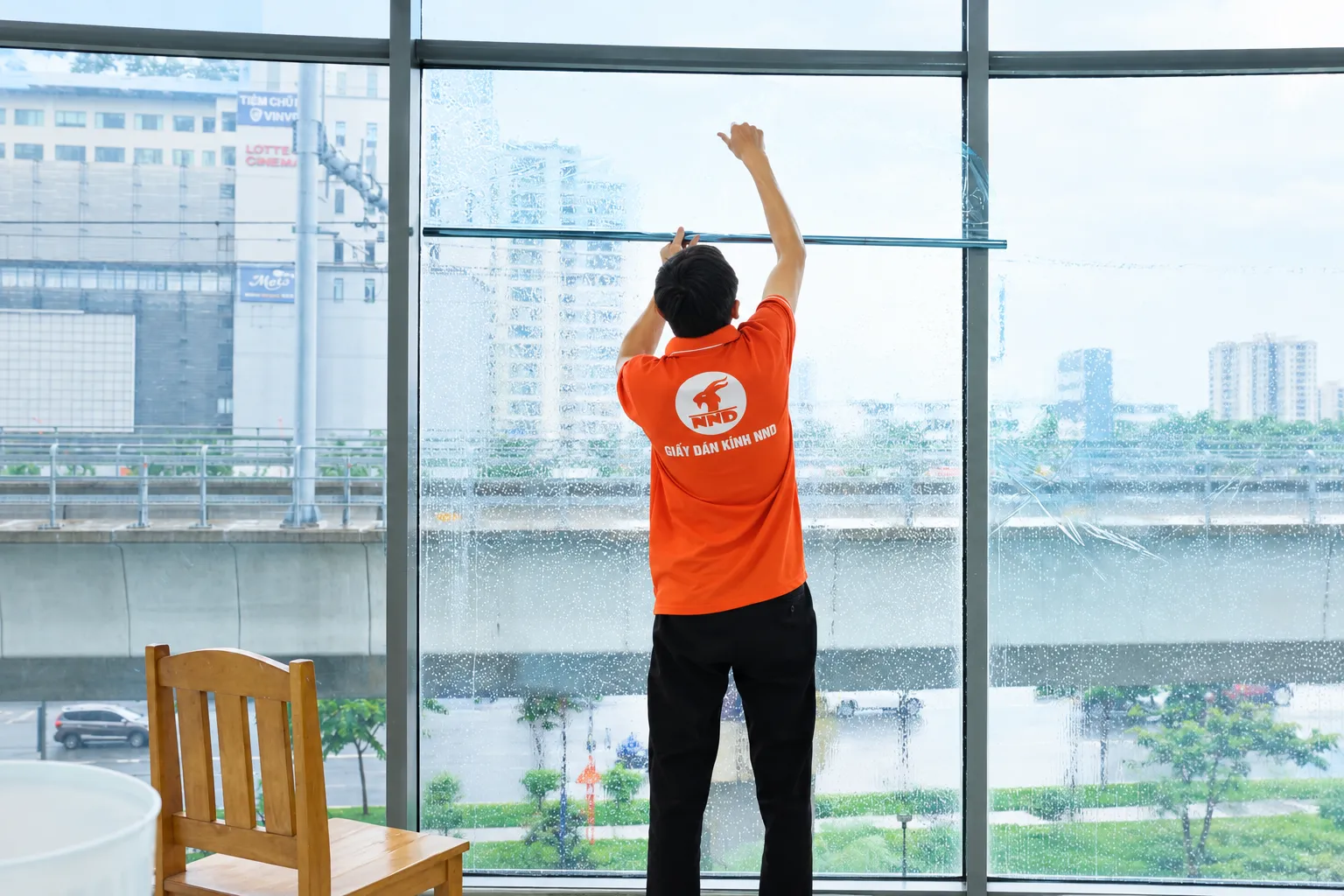 Kỹ thuật viên NND căn mép phim cách nhiệt ở ô kính cao tại tòa nhà Sun Square