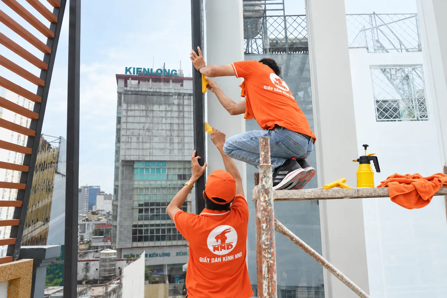 Kỹ thuật viên NND xử lý mép phim cách nhiệt tại nhà phố Kiến Hưng