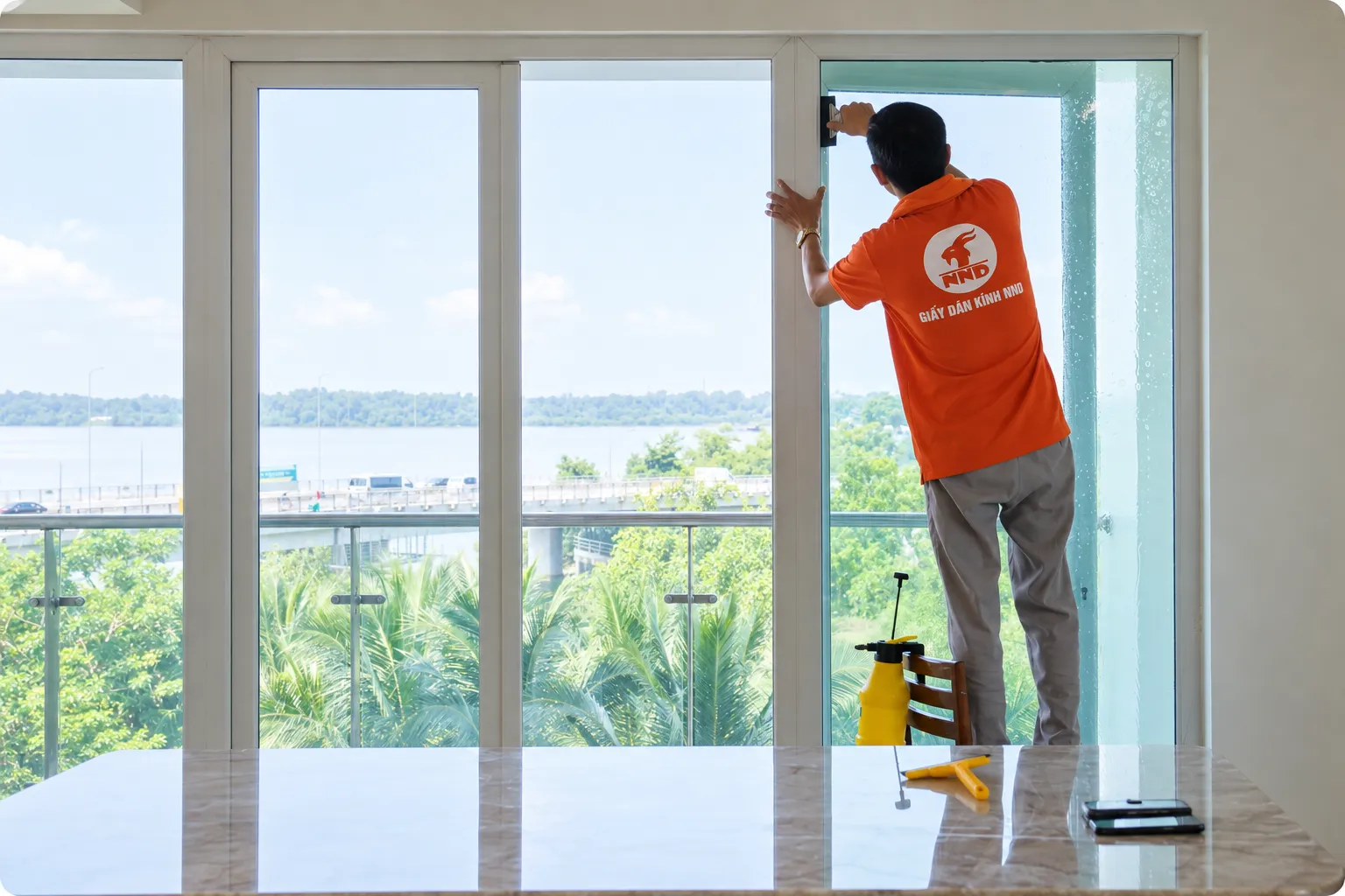 Kỹ thuật viên NND hoàn thiện mép phim cách nhiệt trên cửa kính căn hộ Mipec Riverside