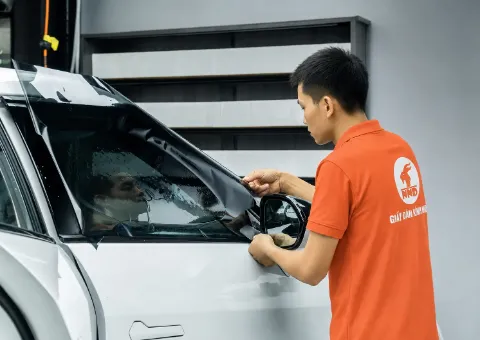 Kỹ thuật viên NND căn chỉnh phim cách nhiệt trên kính sườn ô tô